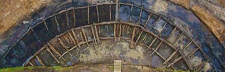 Luftbild des ausgegrabenen Walles, Reihen von kreisförmig angelegten Holzkonstruktionen, die die Größe der Anlage verdeutlichen