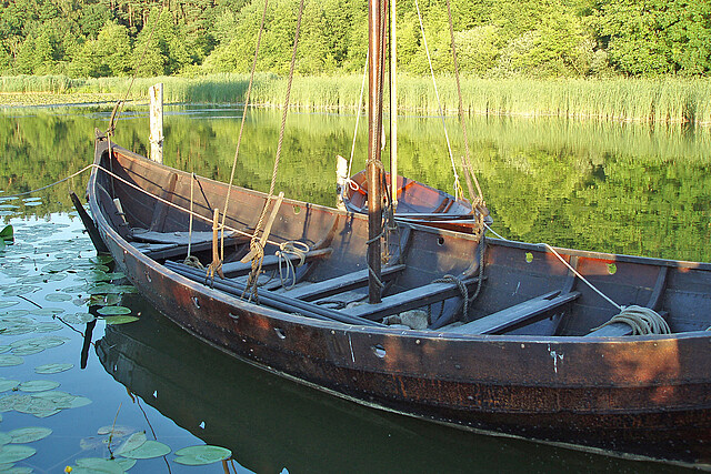Nachbau eines Holzbootes an einem Ufer liegend